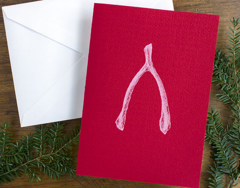 photo of holiday gift card with wish bone on red background